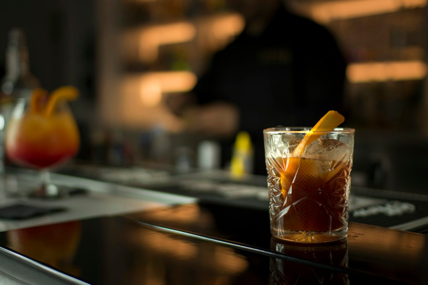 Drink mit Orangenzeste auf der Bartheke