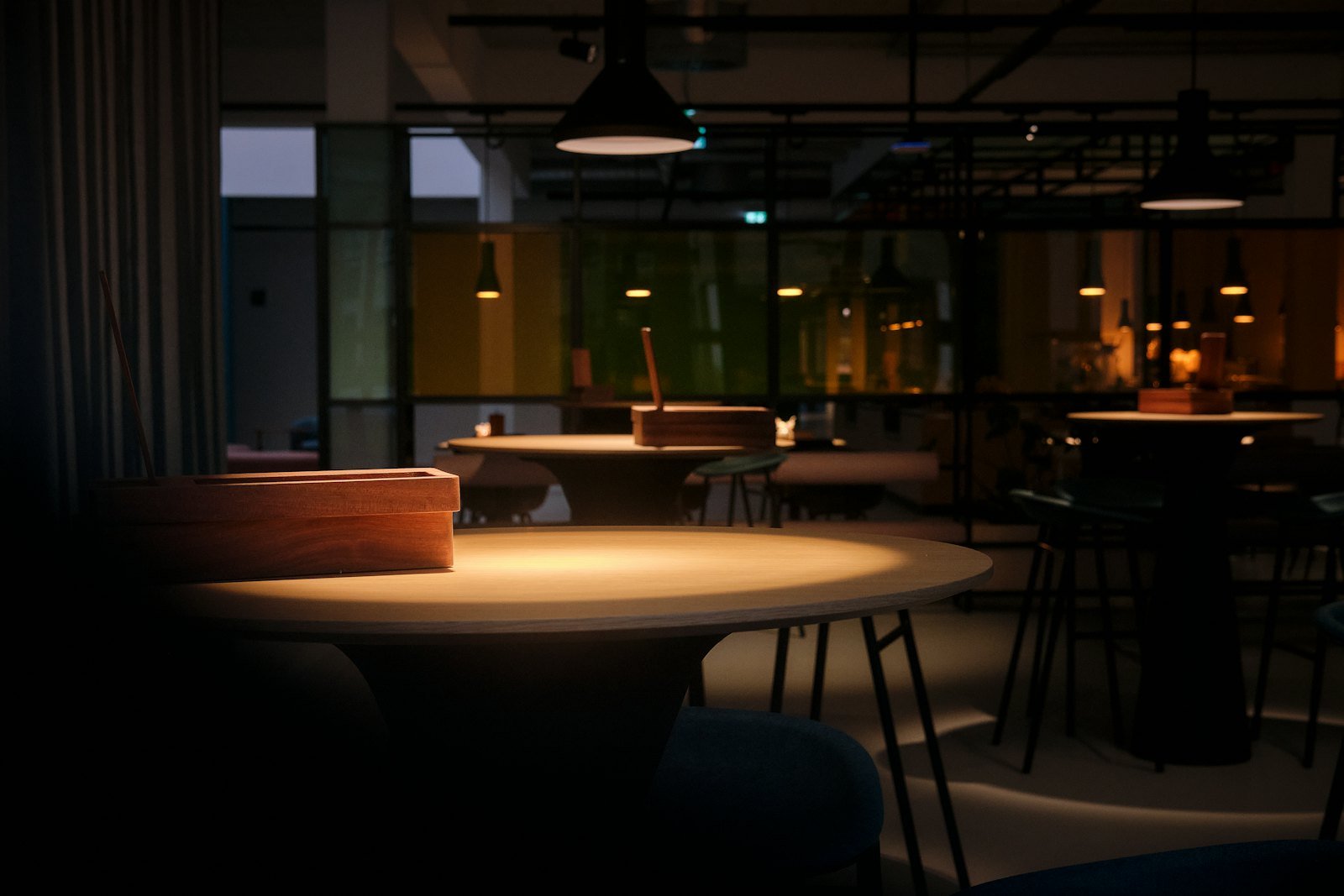 Lounge mit warmer Beleuchtung und runden Tischen